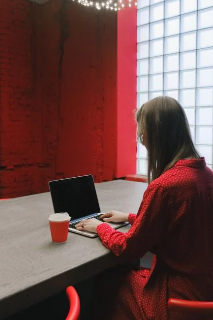 A cozy office setup featuring Christmas decor, a mug, and a laptop screen displaying a website.